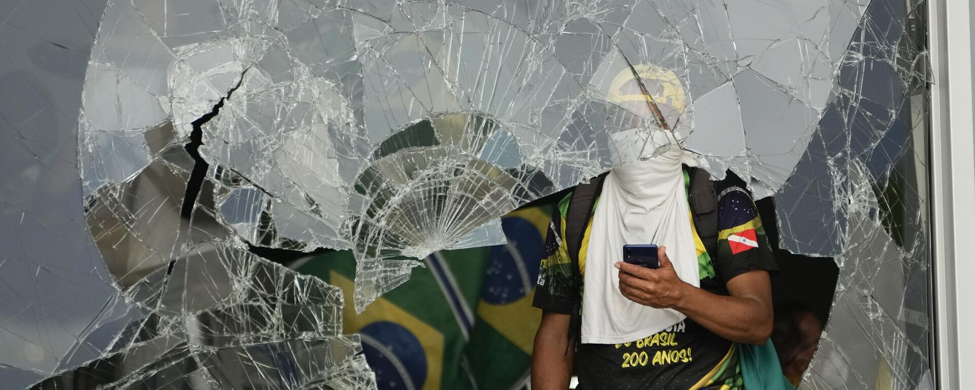 Manifestantes bolsonaristas por trás de janela destruída após invasão no Palácio do Planalto. Brasília (DF), 8 de janeiro de 2023 - Sputnik Brasil, 1920, 08.01.2024