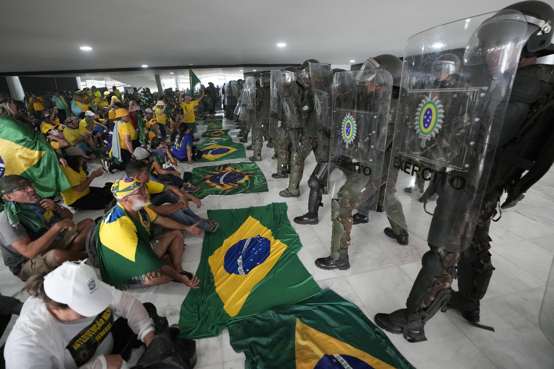 Manifestantes bolsonaristas sentam em frente a agentes do Exército no Palácio do Planalto em meio à invasão de prédios públicos na capital brasileira, Brasília, 8 de janeiro de 2023 - Sputnik Brasil, 1920, 21.07.2023