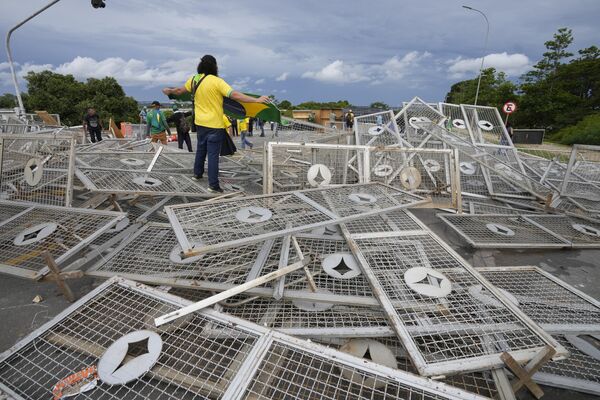 Manifestantes bolsonaristas posam sobre barreiras derrubadas em meio à invasão de prédios públicos na capital brasileira. Brasília, Distrito Federal, 8 de janeiro de 2023 - Sputnik Brasil