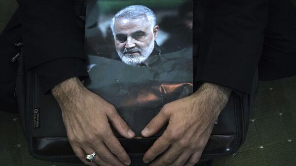 Um enlutado segura um pôster do falecido general da Guarda Revolucionária Qassem Soleimani, durante uma cerimônia que marca o aniversário de sua morte, na Grande Mesquita Imam Khomeini em Teerã, Irã, janeiro 3, 2023 - Sputnik Brasil