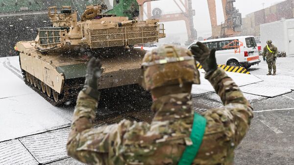 Militar do Exército dos EUA sinaliza o caminho para um tanque M1A2 Abrams no Terminal de Contentores do Báltico em Gdynia, Polônia, EUA, 3 de dezembro de 2022 - Sputnik Brasil