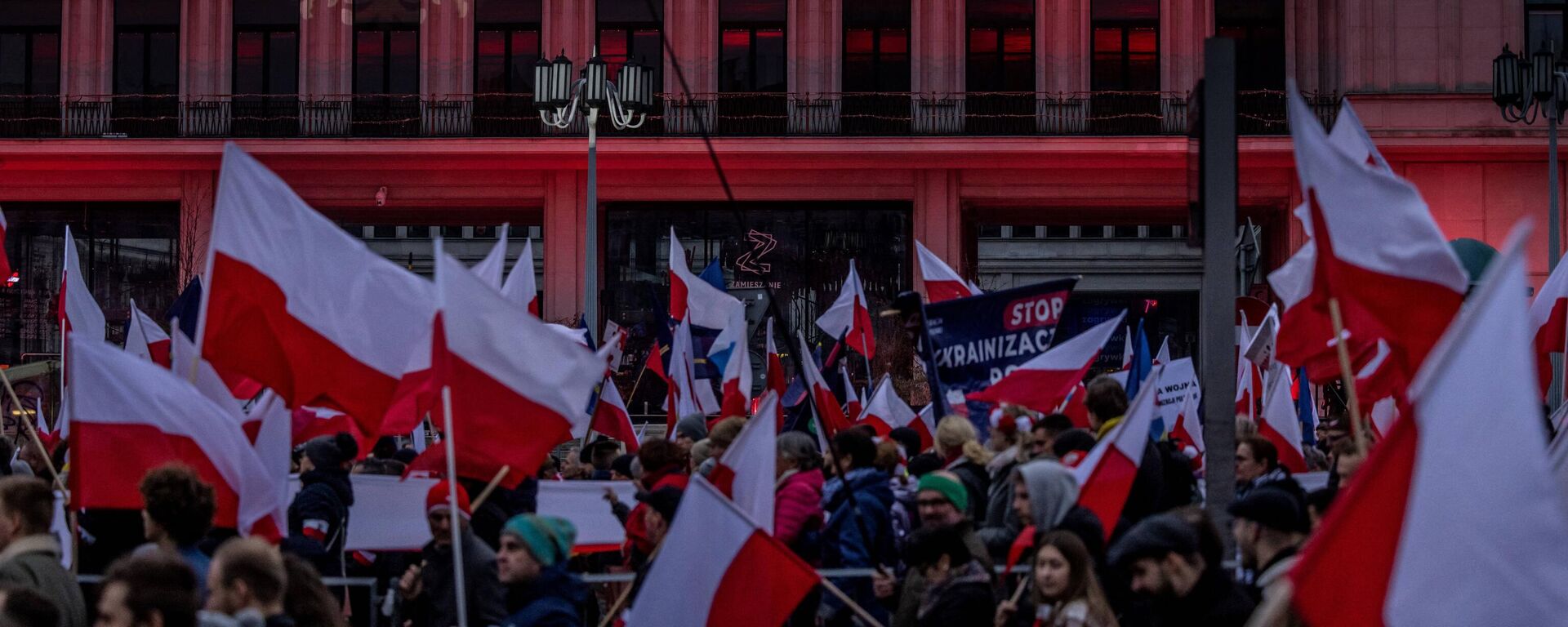 A águia polonesa é projetada na fachada de um prédio enquanto participantes com bandeiras polonesas participam da marcha do Dia da Independência do país organizada em Varsóvia em 11 de novembro de 2022 - Sputnik Brasil, 1920, 21.01.2023