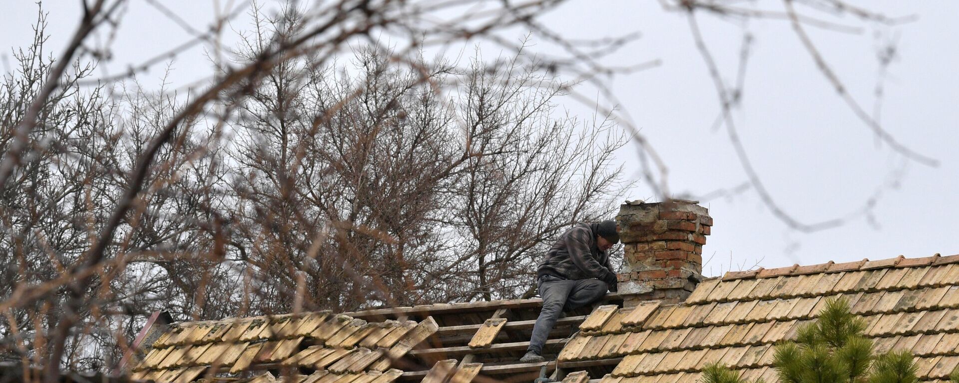 Morador reparando telhado de sua casa perto da cidade de Vasilievka após ataque das Forças Armadas da Ucrânia, foto publicada em 24 de janeiro de 2023. - Sputnik Brasil, 1920, 28.01.2023