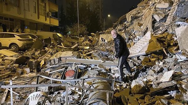 Homem caminha entre destroços de edifícios em Diyarbakir, sudeste da Turquia - Sputnik Brasil