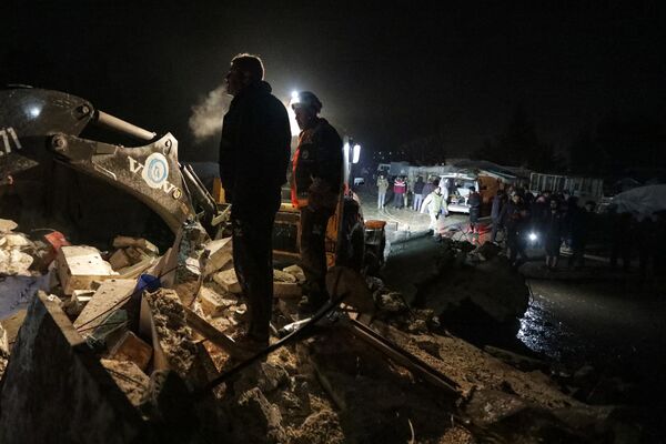Socorristas sírios e moradores reunidos perto de um prédio após o terremoto atingir a cidade fronteiriça de Azaz, na província de Aleppo. - Sputnik Brasil
