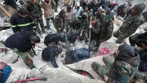 Equipes de resgate sírias procuram por vítimas e sobreviventes debaixo dos escombros de um prédio colapsado após terremoto de magnitude de 7,7, em Aleppo, Síria, 6 de fevereiro de 2023 - Sputnik Brasil