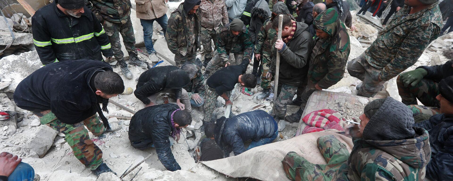 Equipes de resgate sírias procuram por vítimas e sobreviventes debaixo dos escombros de um prédio colapsado após terremoto de magnitude de 7,7, em Aleppo, Síria, 6 de fevereiro de 2023 - Sputnik Brasil, 1920, 06.02.2023