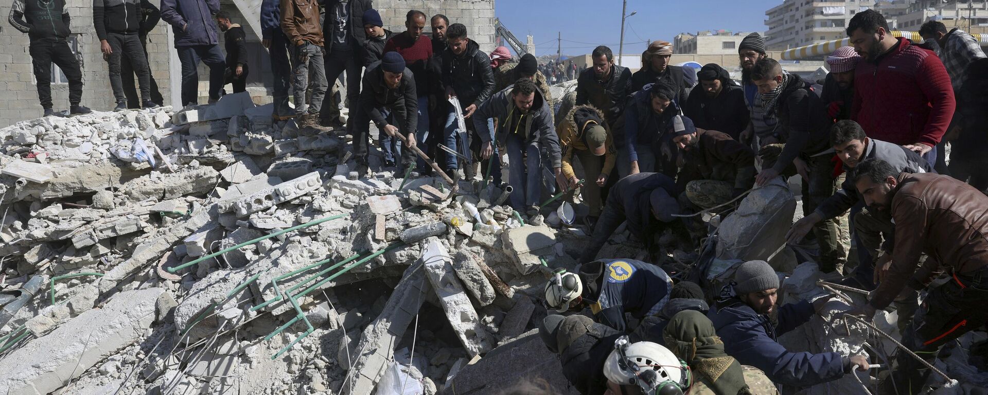 Equipes de resgate e residentes procuram nos escombros de prédios desabados na cidade de Harem, perto da fronteira com a Turquia, província de Idlib, Síria, 8 de fevereiro de 2023 - Sputnik Brasil, 1920, 08.02.2023