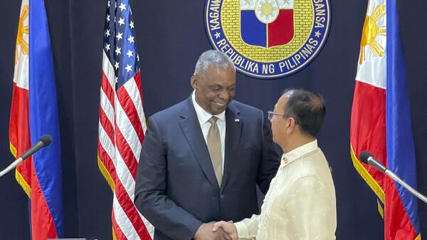 Lloyd Austin, secretário de Defesa dos EUA (à esquerda), e Carlito Galvez, ministro da Defesa das Filipinas (à direita), apertam mãos durante coletiva de imprensa na sede militar filipina no Campo Aguinaldo, Manila, Filipinas, 2 de fevereiro de 2023 - Sputnik Brasil