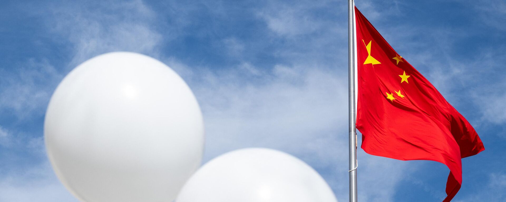Dois balões brancos flutuam perto da bandeira chinesa enquanto o ativista Rev. Patrick Mahoney protesta contra o governo chinês sobre o suposto balão de vigilância chinês que foi abatido sobre os EUA na semana passada, durante uma manifestação do lado de fora da Embaixada da China em Washington, DC, 15 de fevereiro de 2023 - Sputnik Brasil, 1920, 17.02.2023