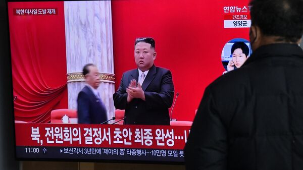 Um homem assiste a uma tela de televisão mostrando um noticiário com imagens de arquivo do líder norte-coreano Kim Jong Un, em uma estação ferroviária em Seul, em 31 de dezembro de 2022 - Sputnik Brasil