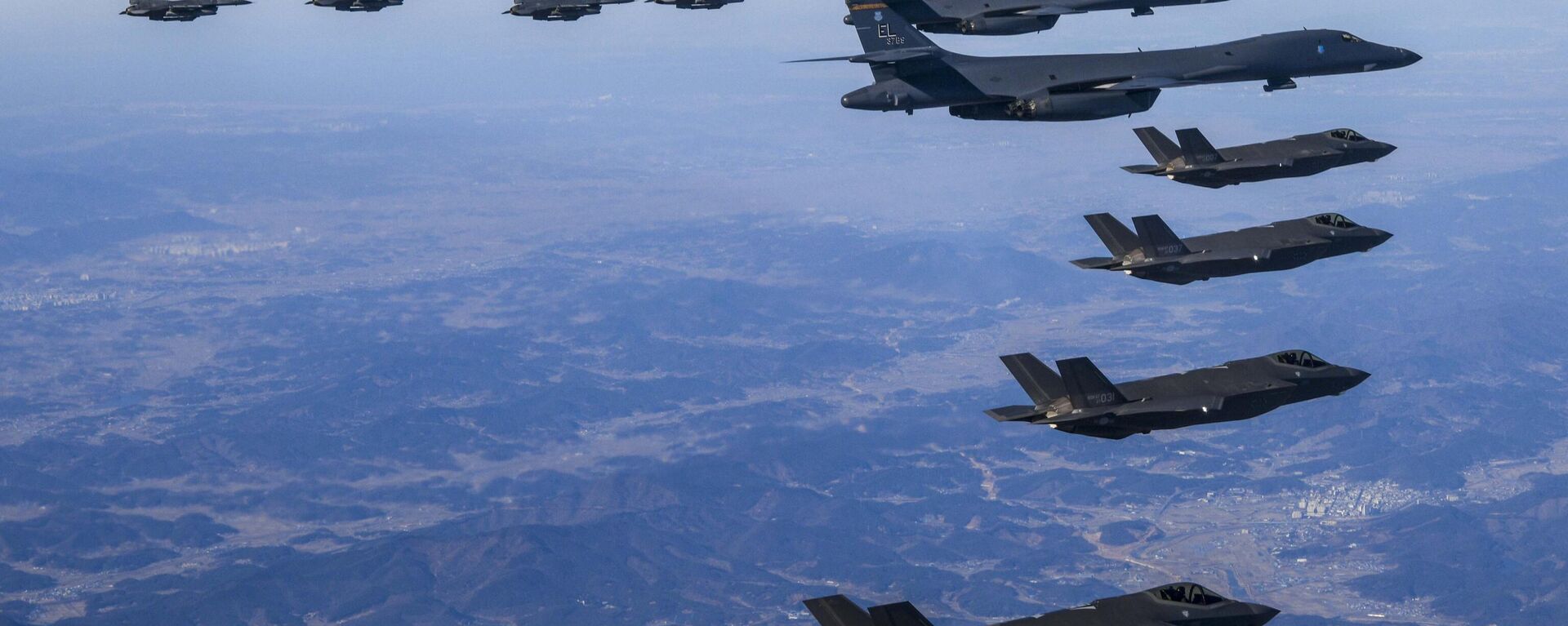 Bombardeiros B-1B dos EUA (no centro) voam em formação com caças F-35A da Coreia do Sul (abaixo) e caças F-16 dos EUA (no topo) sobrevoando a península coreana na Coreia do Sul, 19 de fevereiro de 2023 - Sputnik Brasil, 1920, 14.03.2023