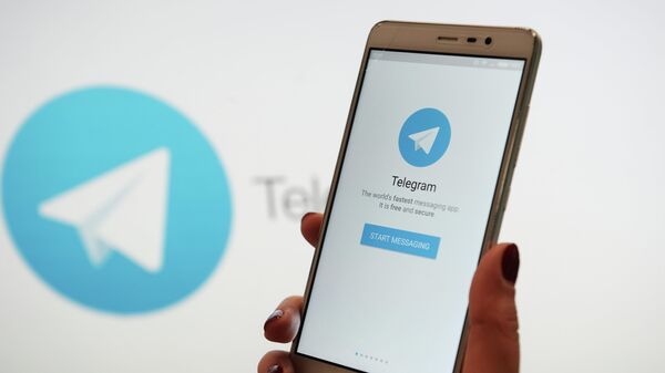 Uma pessoa segura um telefone exibindo o aplicativo Telegram na tela - Sputnik Brasil