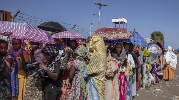 Mulheres Tigray que fugiram do conflito na região de Tigray, na Etiópia, esperam que o Alto-comissariado das Nações Unidas para os Refugiados (ACNUR) distribua cobertores no Centro de Transição de Hamdayet, leste do Sudão, 21 de novembro de 2020 - Sputnik Brasil