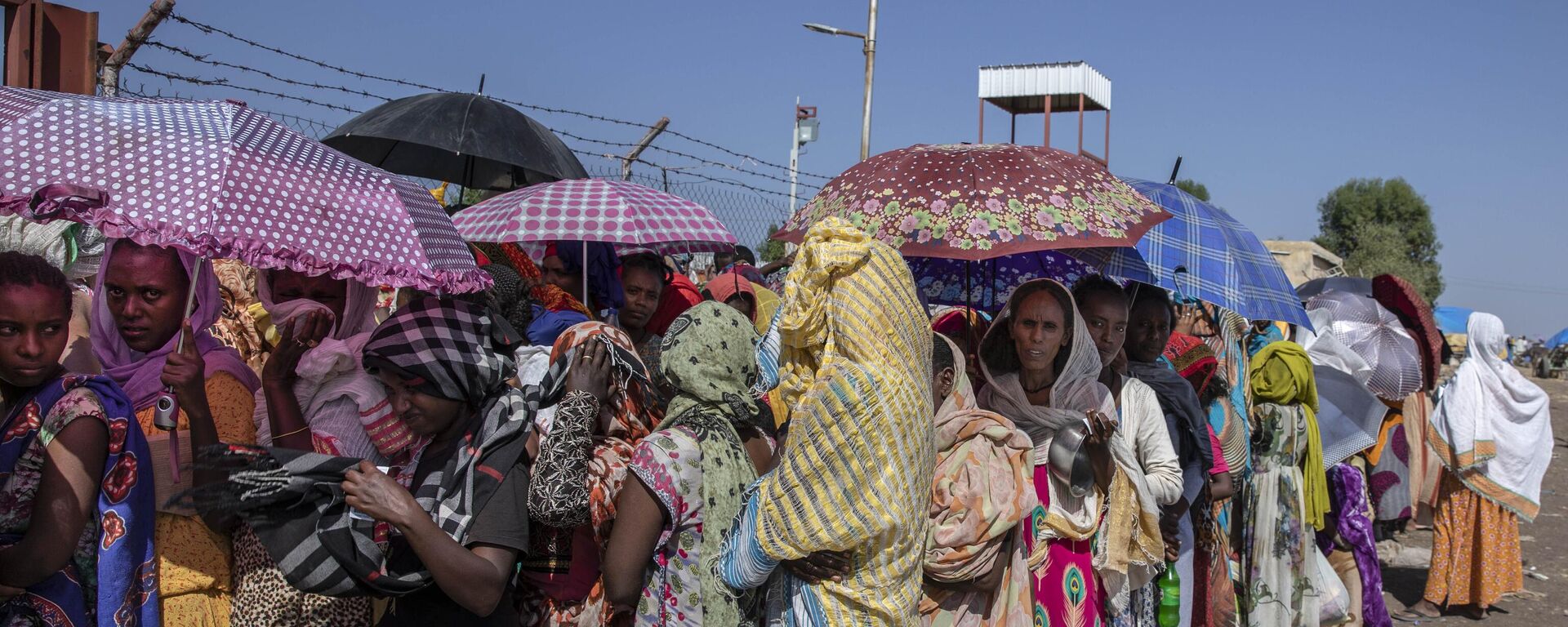Mulheres Tigray que fugiram do conflito na região de Tigray, na Etiópia, esperam que o Alto-comissariado das Nações Unidas para os Refugiados (ACNUR) distribua cobertores no Centro de Transição de Hamdayet, leste do Sudão, 21 de novembro de 2020 - Sputnik Brasil, 1920, 23.02.2023
