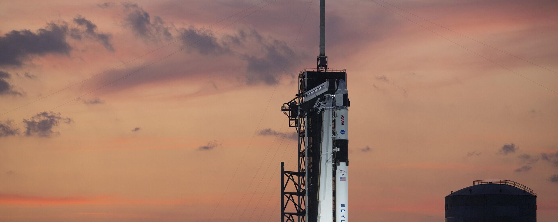 Um foguete da SpaceX Falcon 9 com a nave espacial Dragon, no topo é visto ao pôr do sol na plataforma de lançamento no Complexo de Lançamento 39A enquanto prosseguem os preparativos para a missão Tripulação-6, no sábado, 25 de fevereiro de 2023, no Centro Espacial Kennedy da NASA, na Flórida. - Sputnik Brasil, 1920, 18.03.2023
