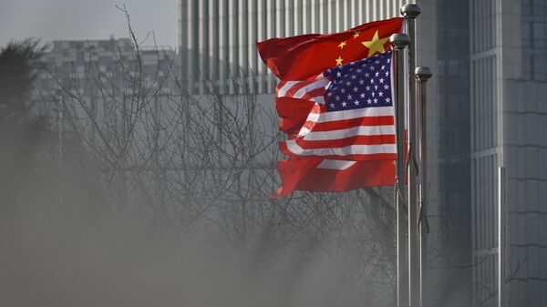 Bandeiras nacionais da China e dos EUA tremulam na entrada de um prédio de escritórios em Pequim, 19 de janeiro de 2020 - Sputnik Brasil