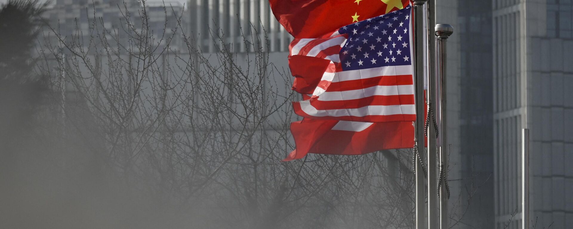 Bandeiras nacionais da China e dos EUA tremulam na entrada de um prédio de escritórios em Pequim, 19 de janeiro de 2020 - Sputnik Brasil, 1920, 05.03.2023