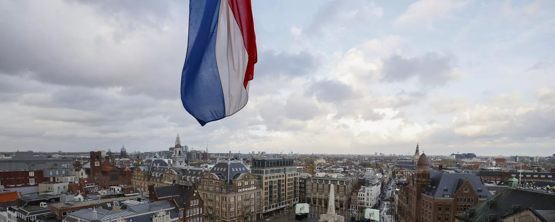 Bandeira holandesa hasteada a meio mastro sobre a Praça Dam, desprovida de espectadores devido a restrições relacionadas ao coronavírus, enquanto o rei holandês Willem-Alexander e a rainha Maxima depositam uma coroa de flores durante uma cerimônia nacional para comemorar os mortos da guerra em Amsterdã, Países Baixos, na terça-feira, 4 de maio de 2021. - Sputnik Brasil, 1920, 31.12.2023