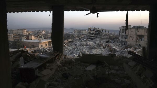 Edifícios desmoronados são vistos pelas janelas de uma casa danificada após um terremoto devastador na cidade de Jinderis, província de Aleppo, Síria, 9 de fevereiro de 2023 - Sputnik Brasil