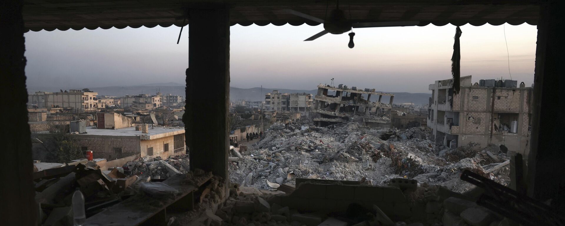 Edifícios desmoronados são vistos pelas janelas de uma casa danificada após um terremoto devastador na cidade de Jinderis, província de Aleppo, Síria, 9 de fevereiro de 2023 - Sputnik Brasil, 1920, 07.03.2023