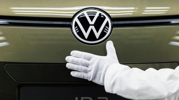 Um funcionário da Volkswagen apresenta o novo logotipo da marca no novo modelo do carro elétrico Volkswagen ID 3 da montadora alemã no local de produção da Fábrica Transparente (Fabricante Glaeserne) em Dresden, leste da Alemanha, 1º de março de 2023 - Sputnik Brasil