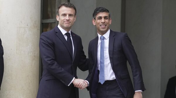 Primeiro-ministro britânico, Rishi Sunak, à direita, e presidente francês, Emmanuel Macron, dão aperto de mãos durante reunião no Palácio do Eliseu em Paris, 10 de março de 2023 - Sputnik Brasil