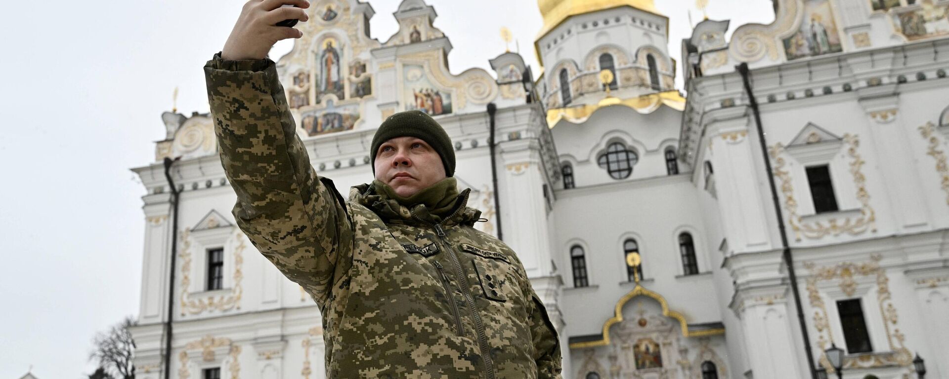 Militar ucraniano faz selfie frente ao Mosteiro da Sagrada Dormição de Kiev-Pechersk, em Kiev, Ucrânia, 7 de janeiro de 2023 - Sputnik Brasil, 1920, 11.03.2023