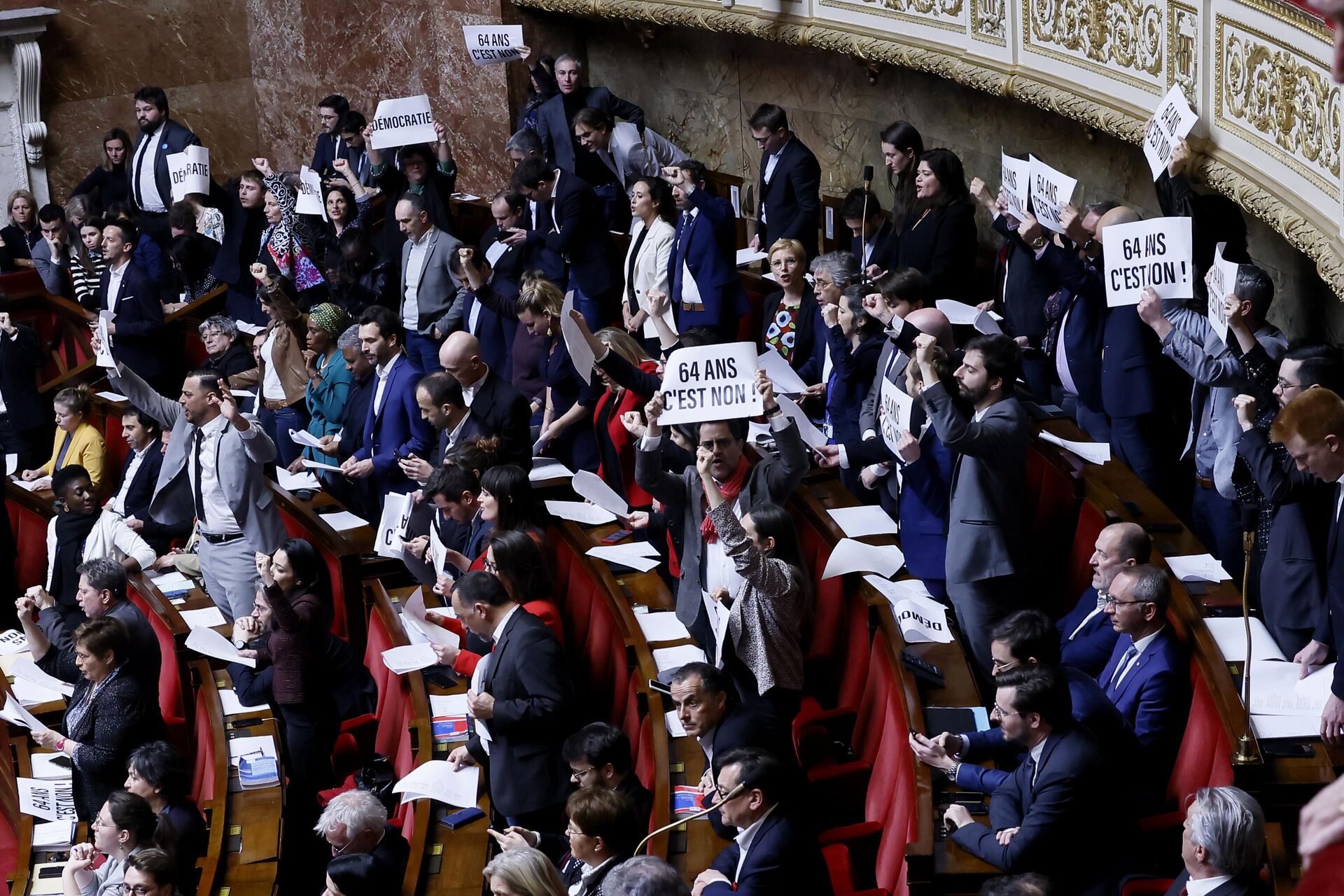 Parlamentares de reagem enquanto seguram um jornal lendo: 64 anos não é na Assembleia Nacional em Paris, 16 de março de 2023 - Sputnik Brasil, 1920, 16.03.2023