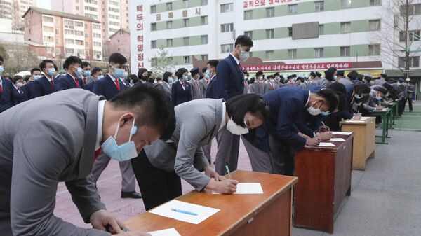 Alunos da Universidade Pyongyang Jang Chol Gu assinam seus nomes na lista de voluntários na capital norte-coreana, 17 de março de 2023 - Sputnik Brasil