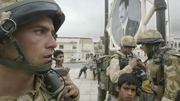 Militares do Reino Unido junto de retrato do presidente iraquiano Saddam Hussein em Basra, Iraque, 7 de abril de 2003 - Sputnik Brasil