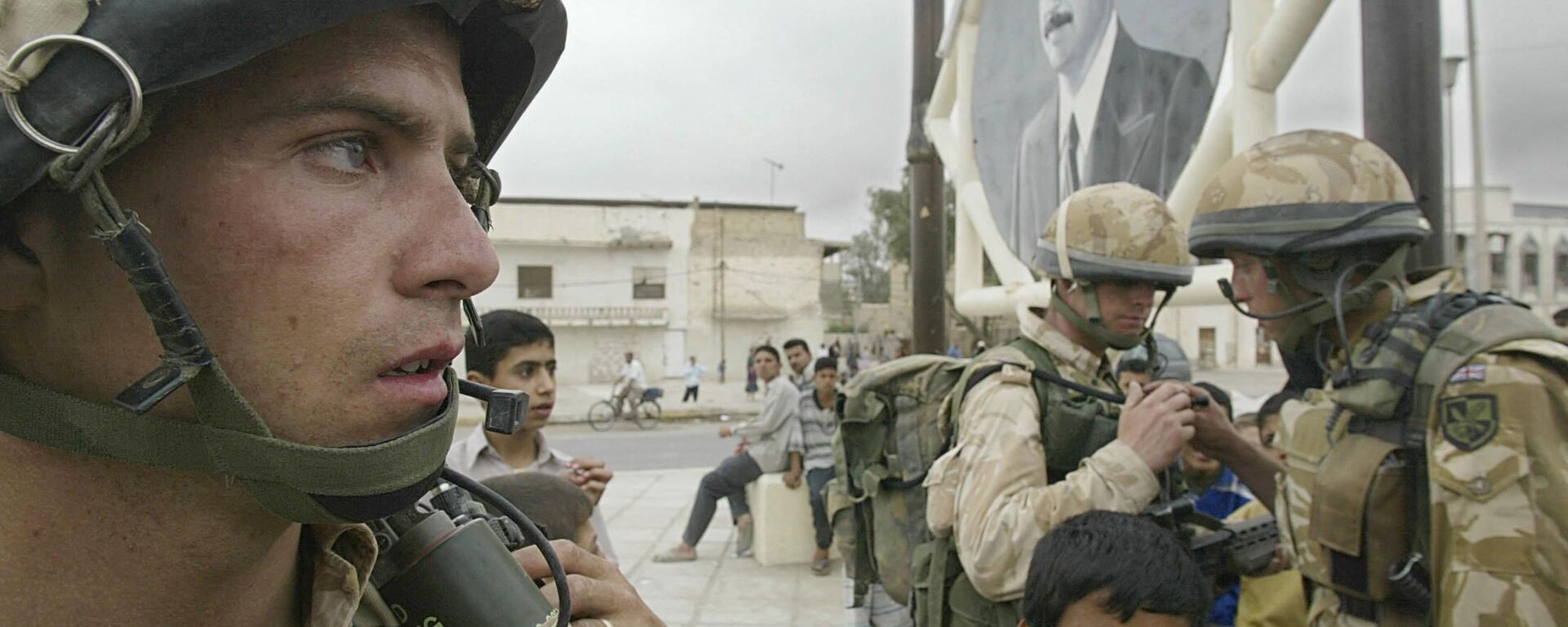 Militares do Reino Unido junto de retrato do presidente iraquiano Saddam Hussein em Basra, Iraque, 7 de abril de 2003 - Sputnik Brasil, 1920, 18.03.2023
