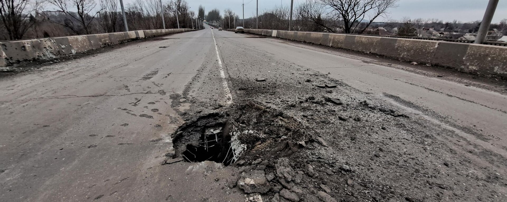 Um buraco é visto na estrada da ponte após um recente bombardeio das Forças Armadas da Ucrânia durante a operação militar especial da Rússia na Ucrânia, na República Popular de Donetsk (RPD) - Sputnik Brasil, 1920, 19.03.2023