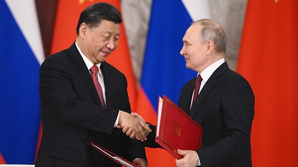 O líder chinês Xi Jinping e o presidente russo Vladimir Putin apertam as mãos após a assinatura de uma declaração conjunta sobre o aprofundamento da parceria abrangente e cooperação estratégica e sobre o plano de desenvolvimento de áreas-chave da cooperação econômica até 2023 no kremlin de moscou, Rússia - Sputnik Brasil