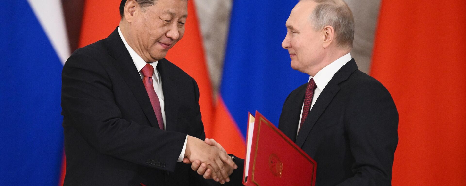Xi Jinping e Vladimir Putin apertam as mãos após a assinatura de uma declaração conjunta sobre o aprofundamento da parceria abrangente e cooperação estratégica e sobre o plano de desenvolvimento de áreas-chave da cooperação econômica até 2023, no Kremlin de Moscou, na Rússia - Sputnik Brasil, 1920, 09.11.2023