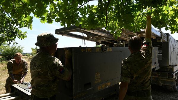 Soldados do 1º Exército Britânico de Artilharia Real a Cavalo carregam munições para o lançador múltiplo de foguetes autopropulsionado M270 durante exercícios militares Dynamic Front 22, em Grafenwoehr, Alemanha, 20 de julho de 2022 - Sputnik Brasil