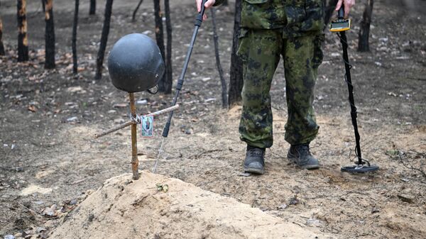 Sapeiro da Guarda Nacional da Rússia observa túmulo de posições anteriores das Forças Armadas da Ucrânia, foto publicada em 20 de março de 2023 - Sputnik Brasil