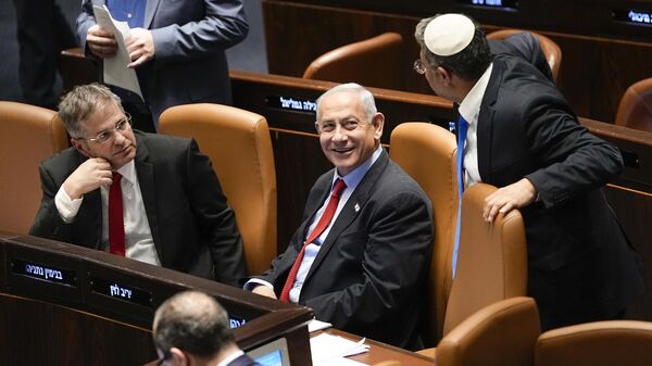 O primeiro-ministro israelense Benjamin Netanyahu, ao centro, sorri enquanto Itamar Ben Gvir, ministro da segurança nacional, e o ministro da Educação, Yoav Kisch, à esquerda, olham para o parlamento de Israel, o Knesset, em Jerusalém, 22 de fevereiro de 2023 - Sputnik Brasil