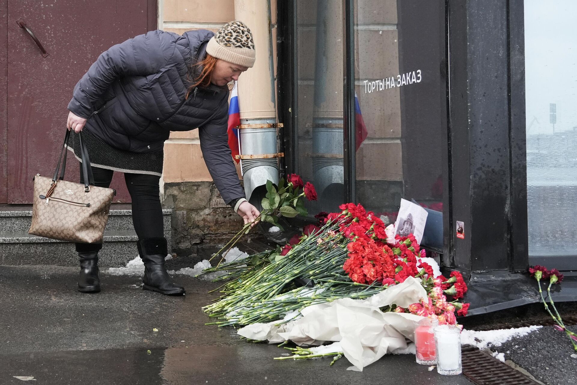 Uma mulher coloca flores perto do local de uma explosão em um café que matou o blogueiro militar Vladlen Tatarsky em São Petersburgo, Rússia. Pelo menos uma pessoa morreu e 32 ficaram feridas pela explosão de um artefato explosivo não identificado em um café em 2 de abril de 2023 - Sputnik Brasil, 1920, 04.04.2023