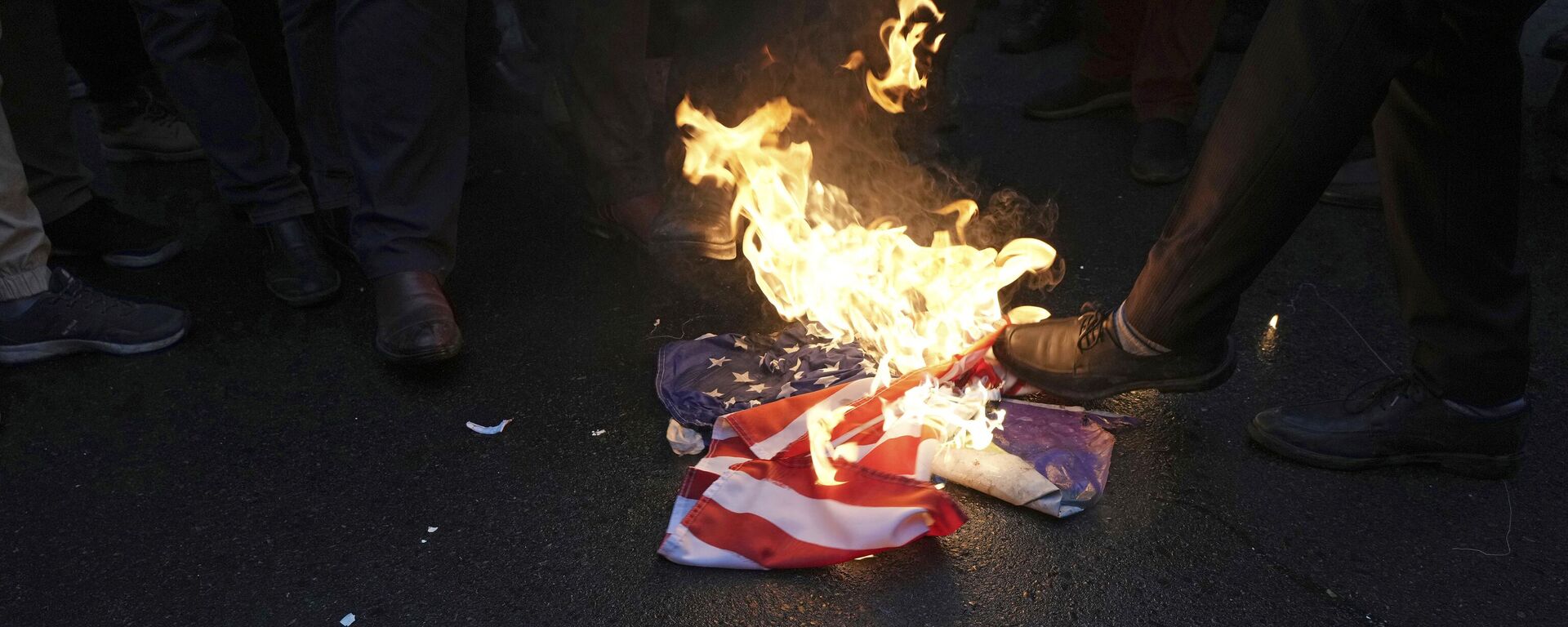 Manifestantes iranianos queimam a bandeira dos EUA durante um protesto contra as caricaturas publicadas pela revista satírica francesa Charlie Hebdo, que ridicularizam os clérigos governantes do Irã, em frente à embaixada da França em Teerã no Irã, 11 de janeiro de 2023. - Sputnik Brasil, 1920, 11.04.2023