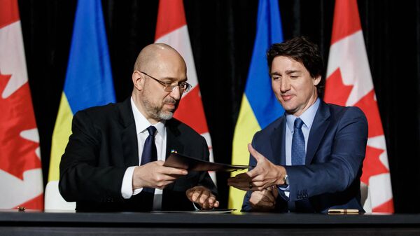 O primeiro-ministro canadense Justin Trudeau (à direita) e o primeiro-ministro ucraniano Denys Shmyhal (à esquerda) assinam um acordo durante uma coletiva de imprensa bilateral em Toronto, Canadá, em 11 de abril de 2023 - Sputnik Brasil
