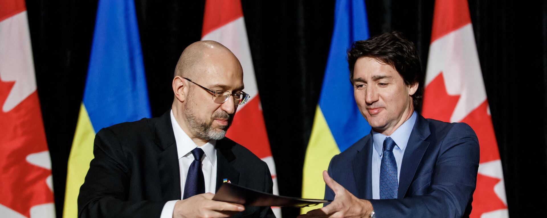 O primeiro-ministro canadense Justin Trudeau (à direita) e o primeiro-ministro ucraniano Denys Shmyhal (à esquerda) assinam um acordo durante uma coletiva de imprensa bilateral em Toronto, Canadá, em 11 de abril de 2023 - Sputnik Brasil, 1920, 11.04.2023