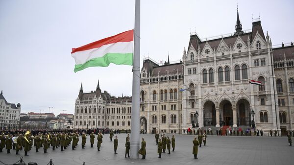 Guardas de honra húngaros içam a bandeira nacional em frente ao edifício do parlamento em Budapeste, Hungria, 15 de março de 2023. - Sputnik Brasil