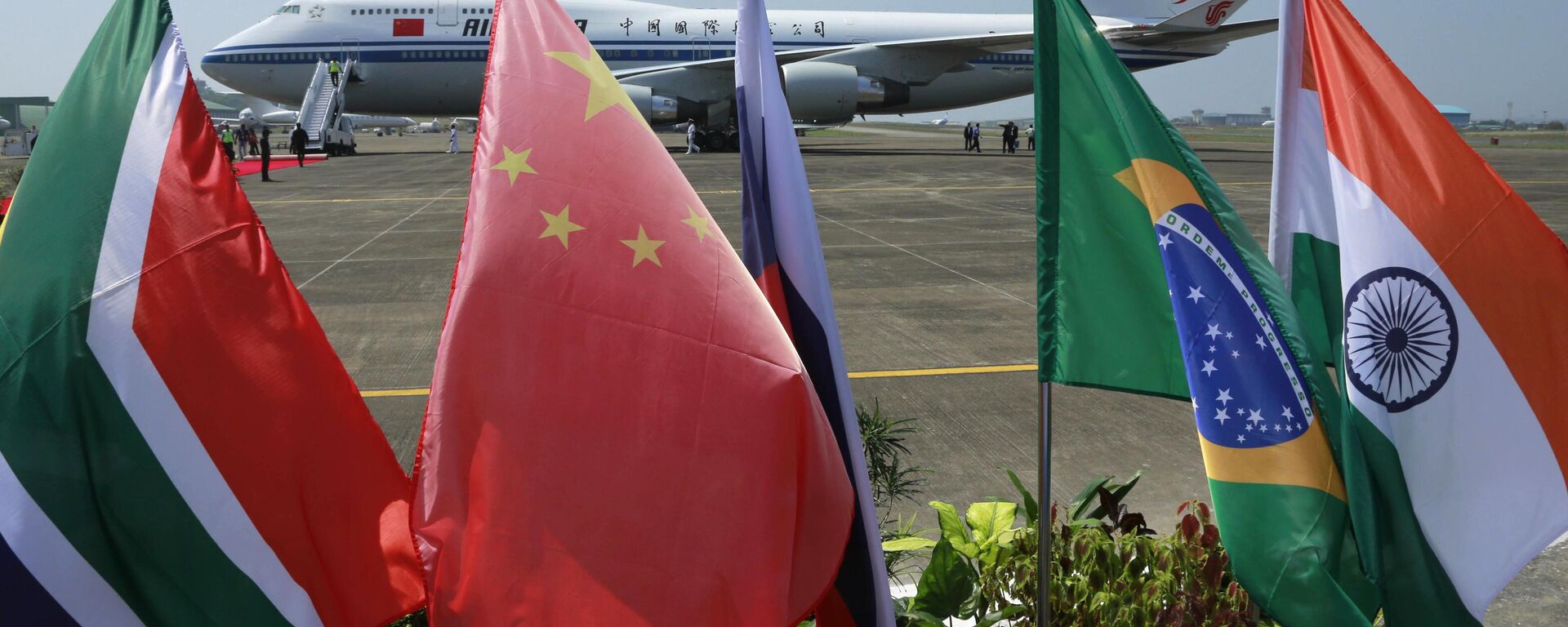 Bandeiras dos cinco países que compõem o BRICS tremulam na frente de uma aeronave da Air China na qual o presidente chinês Xi Jinping chegou para participar da cúpula do BRICS em Goa, Índia, 15 de outubro de 2016 - Sputnik Brasil, 1920, 13.04.2023