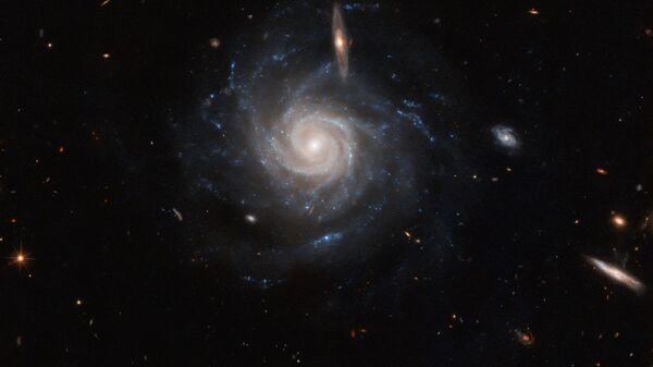 O Telescópio Espacial Hubble registrou a galáxia espiral barrada UGC 678, localizada no centro da imagem divulgada pela NASA, a 260 milhões de anos-luz da Terra, na constelação de Peixes - Sputnik Brasil