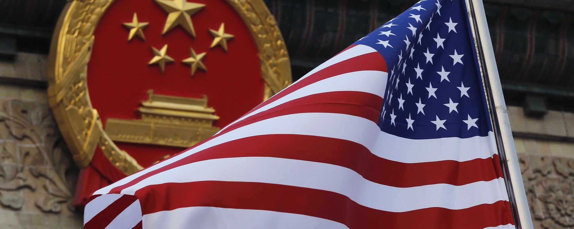 Uma bandeira americana é hasteada ao lado do emblema nacional chinês durante uma cerimônia de boas-vindas à visita do presidente dos EUA Donald Trump fora do Grande Salão do Povo em Pequim, 9 de novembro de 2017. - Sputnik Brasil, 1920, 18.04.2023