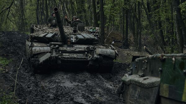 Soldados ucranianos acenam sobre um tanque que passa na linha de frente em Artyomovsk (Bakhmut, na versão ucraniana), região de Donetsk, Ucrânia, 23 de abril de 2023. - Sputnik Brasil