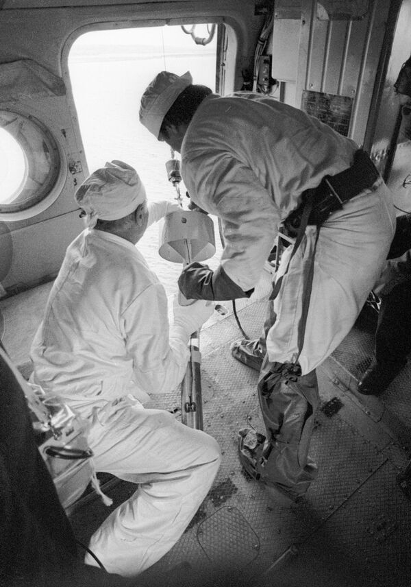 Especialistas a bordo de um helicóptero coletam amostras de água nos refrigeradores do reator de Chernobyl após a catástrofe. - Sputnik Brasil