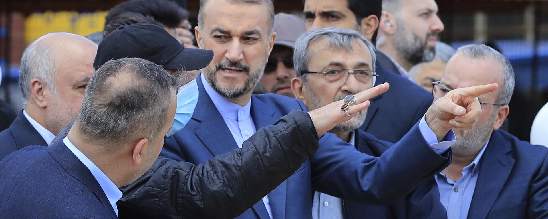 O ministro das Relações Exteriores do Irã, Hossein Amirabdollahian, ao centro, escoltado por membros do Hezbollah e legisladores aponta para o lado israelense durante sua visita ao parque do Irã, na vila de Maroun el-Rass, na fronteira Líbano-Israel, sul do Líbano, 28 de abril de 2023 - Sputnik Brasil, 1920, 28.04.2023