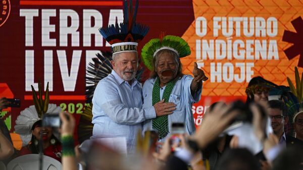 O presidente brasileiro Luiz Inácio Lula da Silva (L) e o líder indígena da tribo Kayapó Cacique Raoni Metuktire (R) gesticulam durante uma visita ao Acampamento Indígena Terra Livre em Brasília em 28 de abril de 2023 - Sputnik Brasil